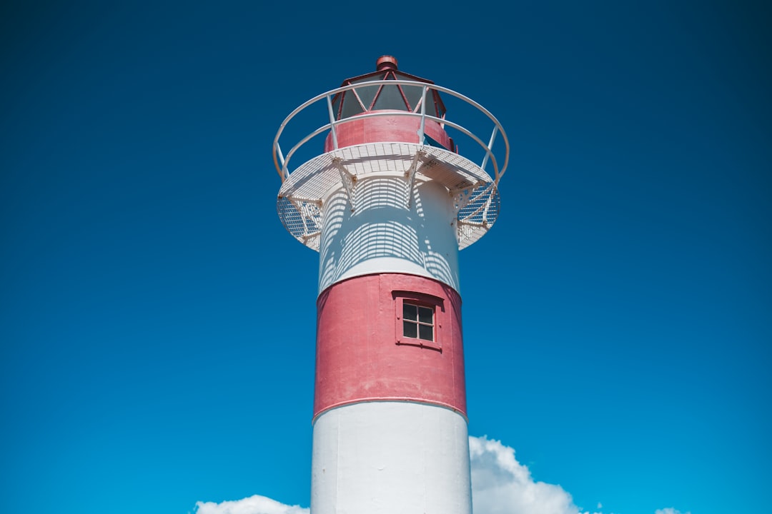 red and white lighthouse under blue sky during daytime