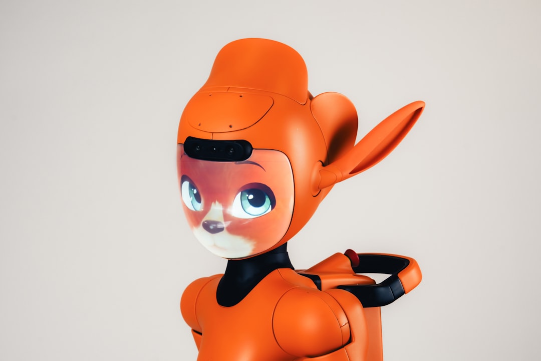 An orange robot with a digital screen face displaying a fox-like character