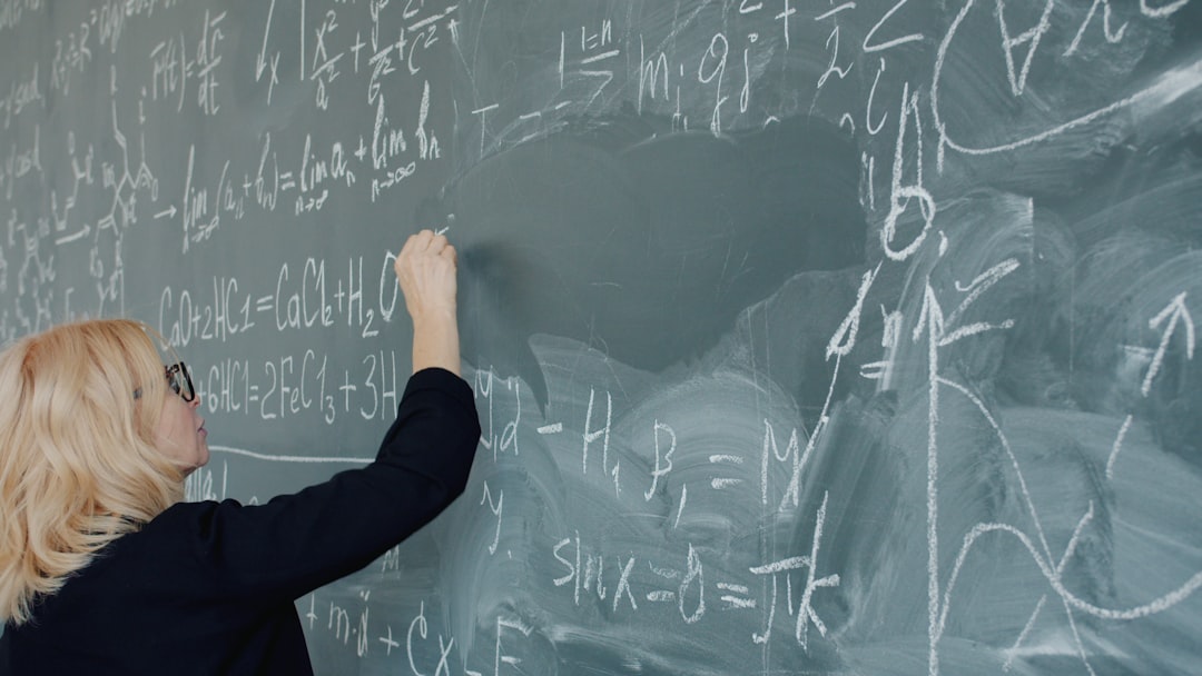 Woman writing complex mathematical equations on a chalkboard