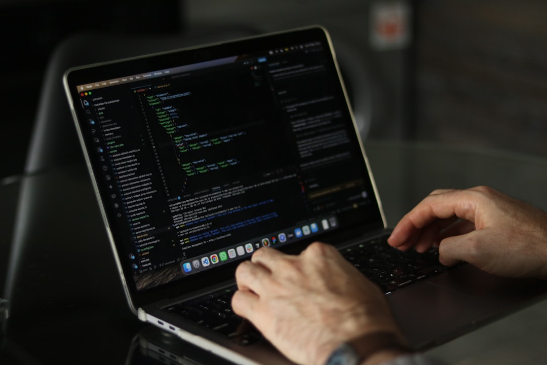 Hands typing code on a laptop keyboard